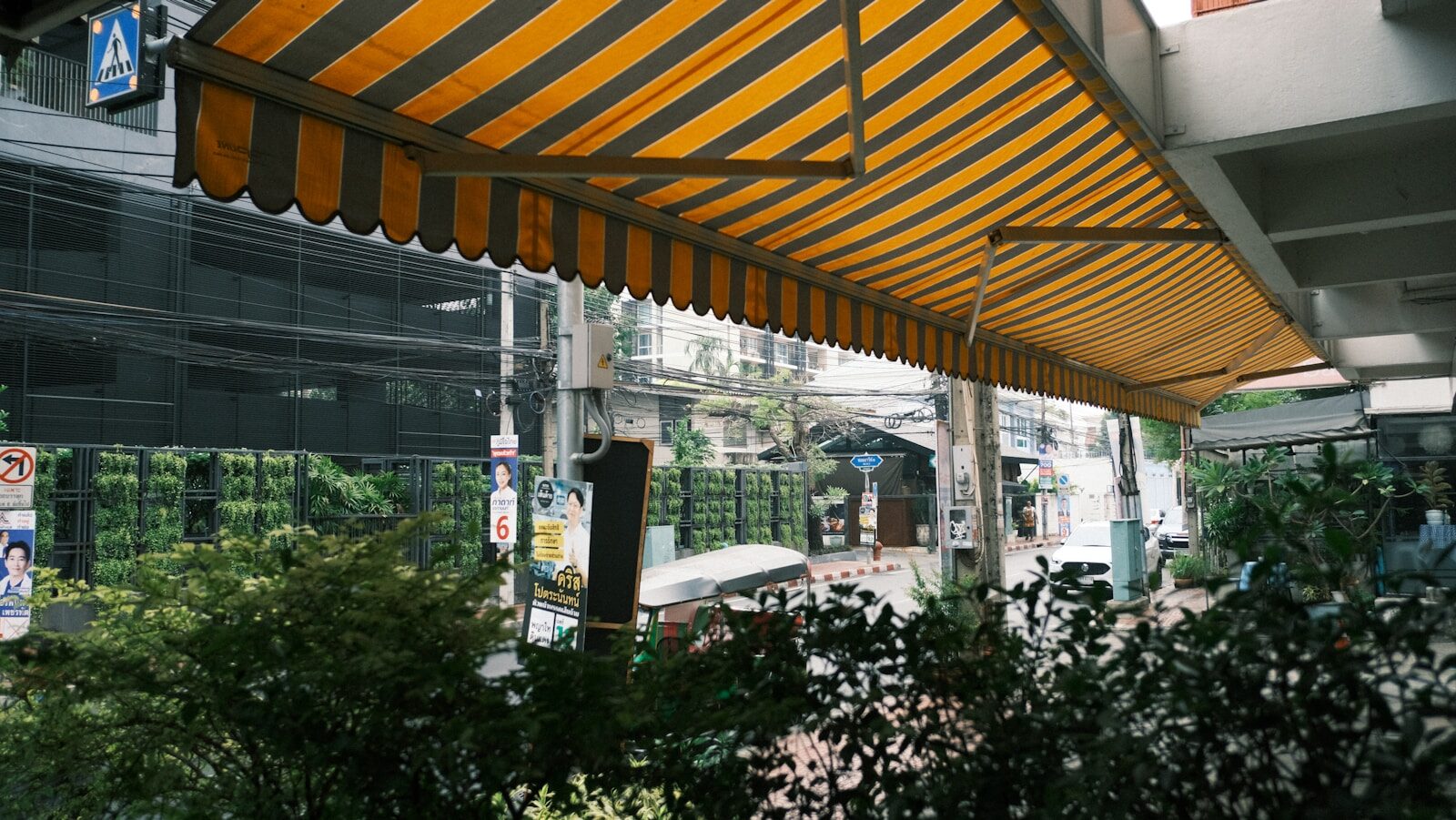 a yellow and black striped awning over a street